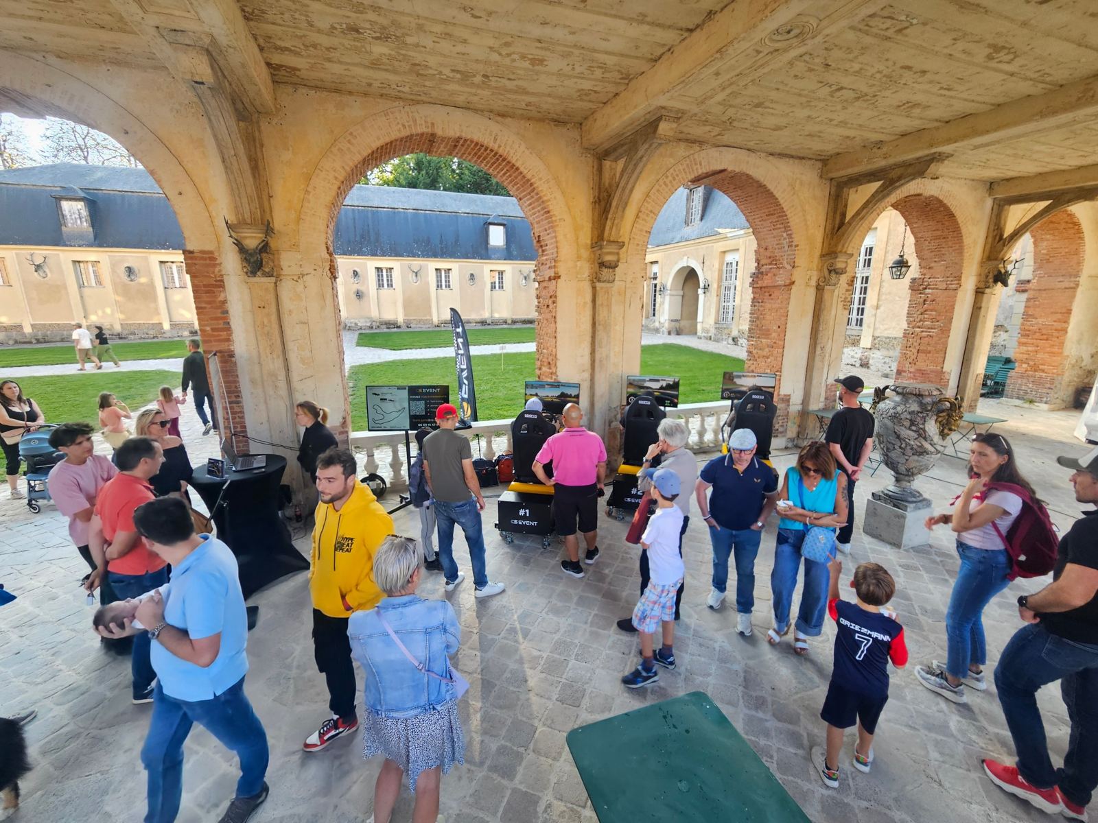 Public autour des simulateurs sous les arcades du château de Dampierre-en-Yvelines