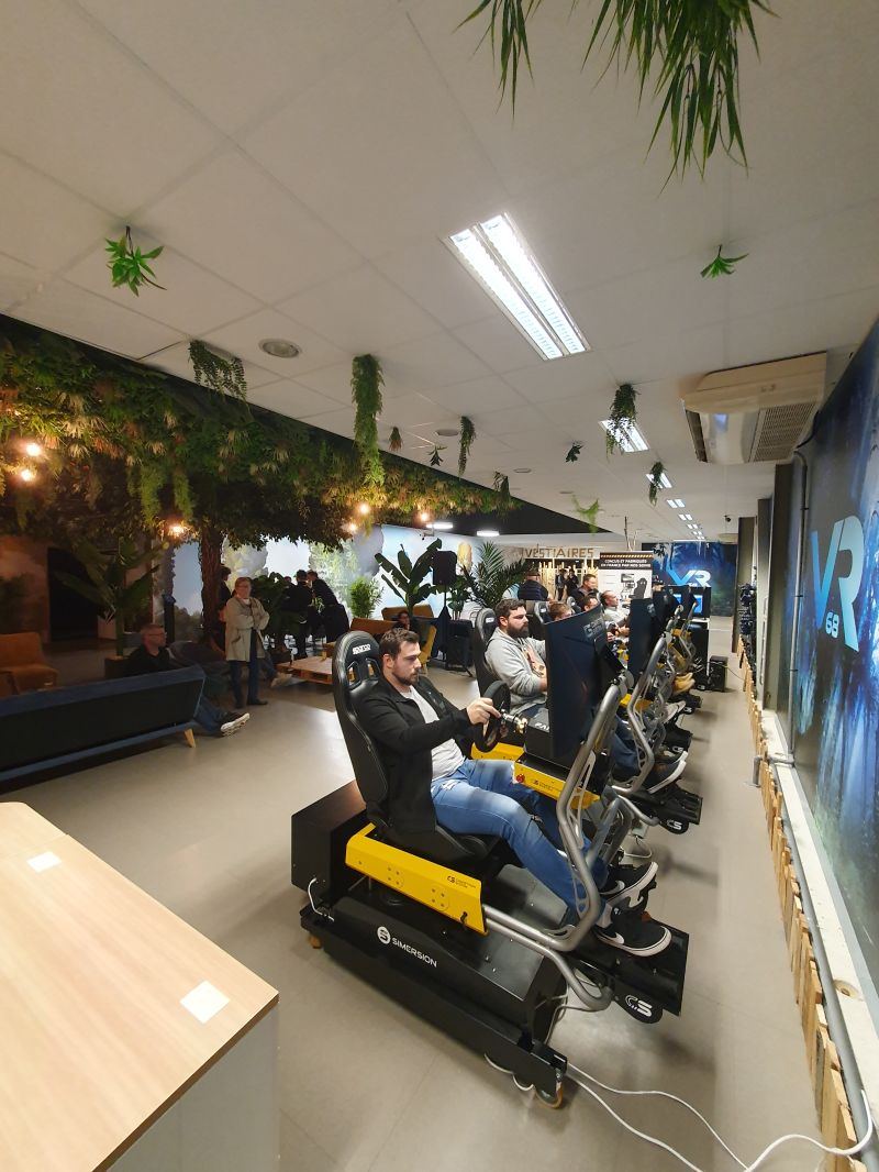Rangée de simulateurs en action dans un espace de loisirs