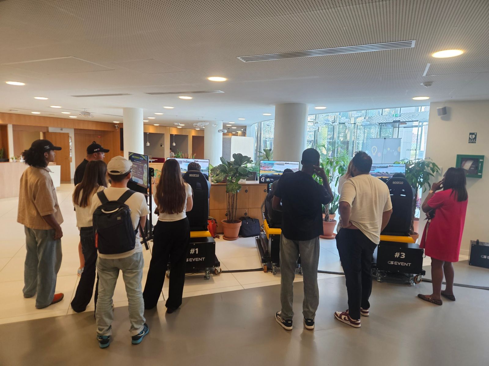 Participants autour des simulateurs dans le hall de Spaces La Défense